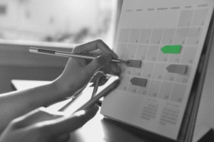 Person filling out a calendar, planing for the college recruiting timeline.