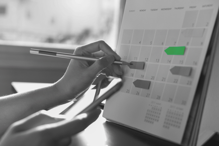 Person filling out a calendar, planing for the college recruiting timeline.