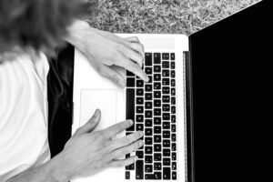 High school athlete drafting a college recruiting email to a coach on a laptop.