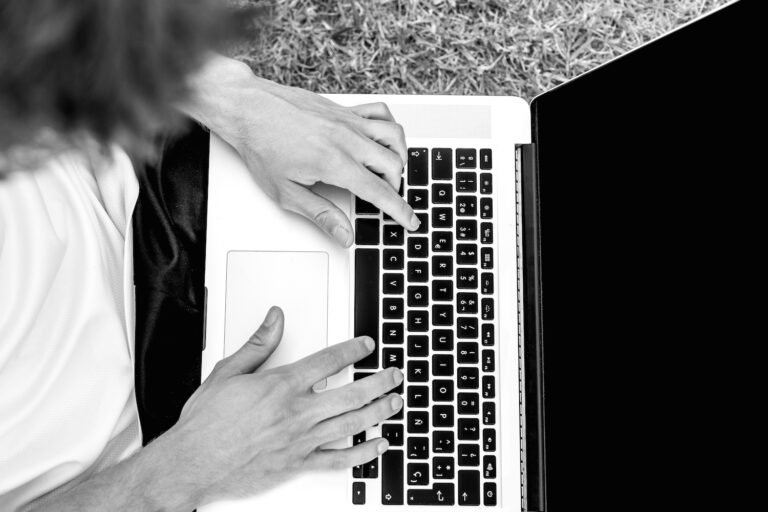 High school athlete drafting a college recruiting email to a coach on a laptop.