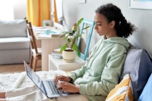 Alt Text Student athlete researching how to follow up with college coaches on a laptop