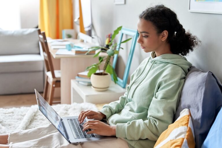 Alt Text Student athlete researching how to follow up with college coaches on a laptop