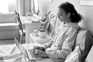 Alt Text Student athlete researching how to follow up with college coaches on a laptop