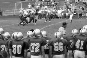 College Coaches watching a high school football game.